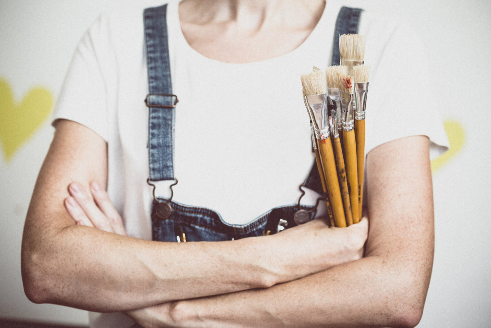 A painter holding a brush at work on a canvas